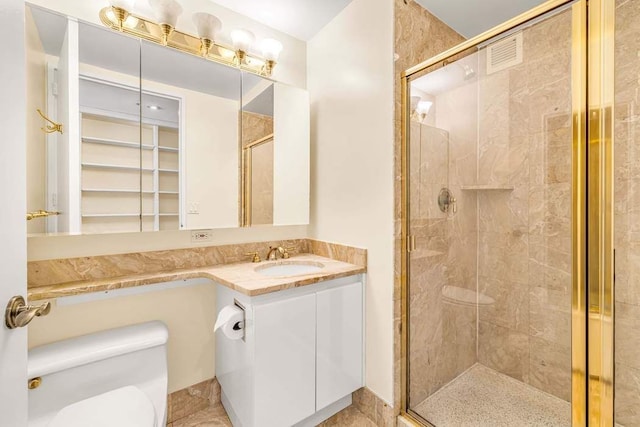 bathroom featuring toilet, a stall shower, and vanity