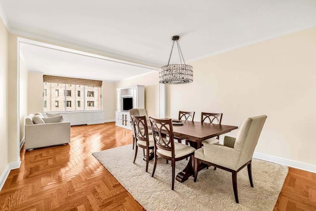 dining area featuring baseboards, crown molding, and an inviting chandelier