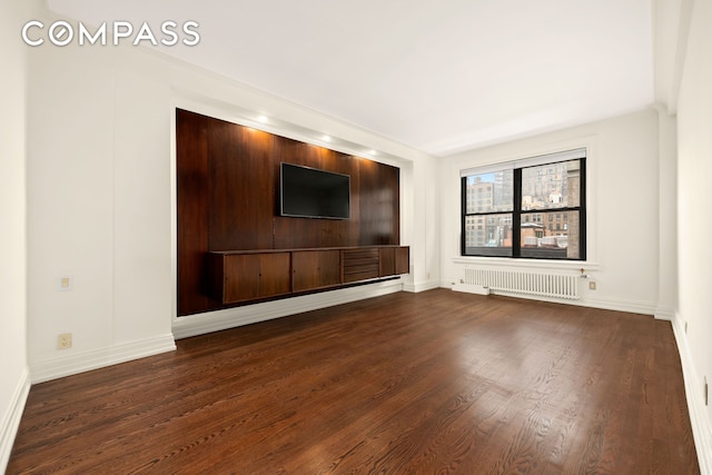 unfurnished living room with dark wood-style floors, radiator, and baseboards