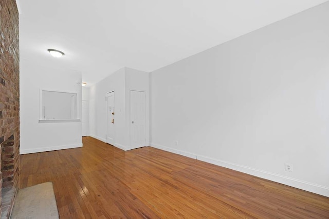 empty room featuring baseboards and hardwood / wood-style flooring