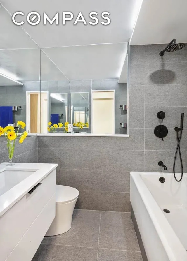 bathroom with vanity, tile walls, toilet, and tile patterned flooring