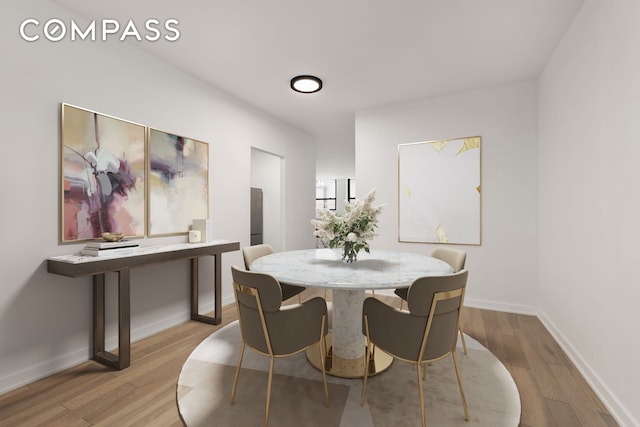 dining area featuring light wood-style floors and baseboards