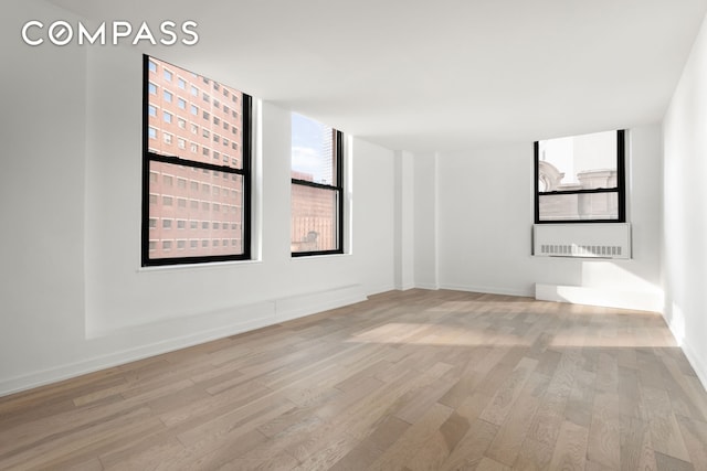 empty room with light wood-type flooring and baseboards