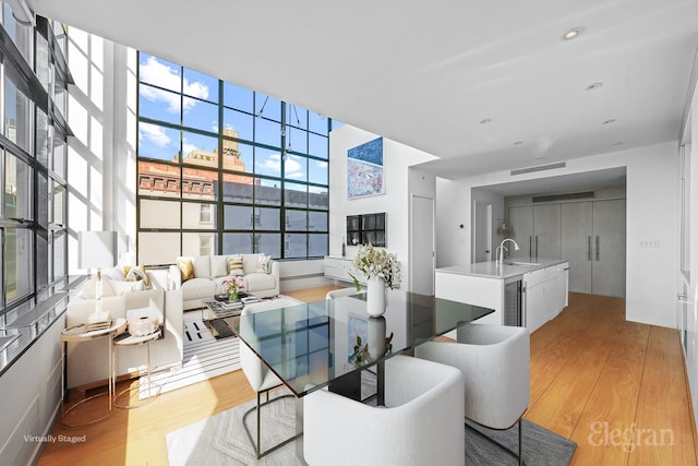 dining space featuring wine cooler and light wood-style floors