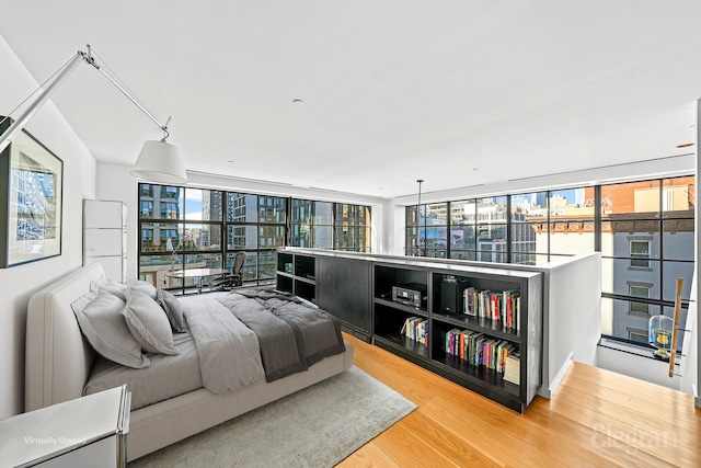 bedroom with floor to ceiling windows and light wood finished floors