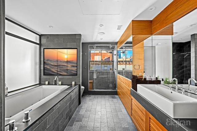 bathroom featuring vanity, a garden tub, a shower stall, and toilet