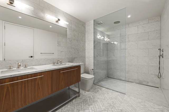 bathroom with tile walls, a sink, toilet, and walk in shower