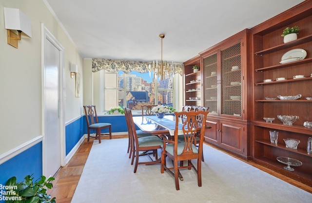 dining space featuring baseboards, a notable chandelier, and crown molding