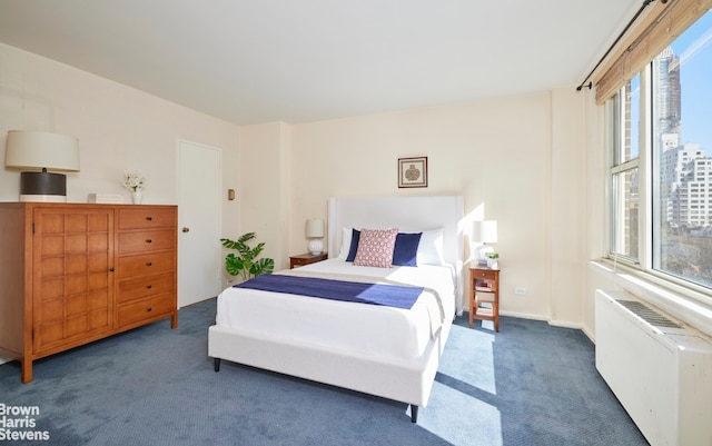 carpeted bedroom featuring multiple windows and radiator heating unit