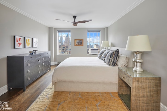 bedroom featuring ceiling fan, baseboards, wood finished floors, and ornamental molding