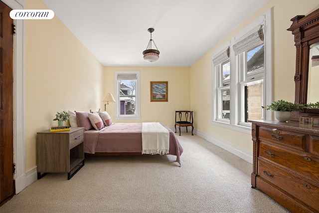 bedroom with visible vents, light colored carpet, and baseboards