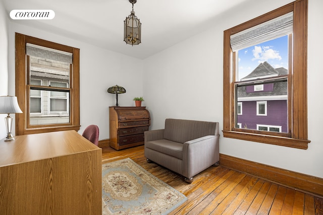 living area featuring visible vents, baseboards, a chandelier, and hardwood / wood-style flooring