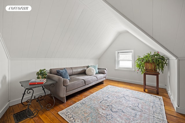 living room with visible vents, lofted ceiling, baseboards, and hardwood / wood-style flooring