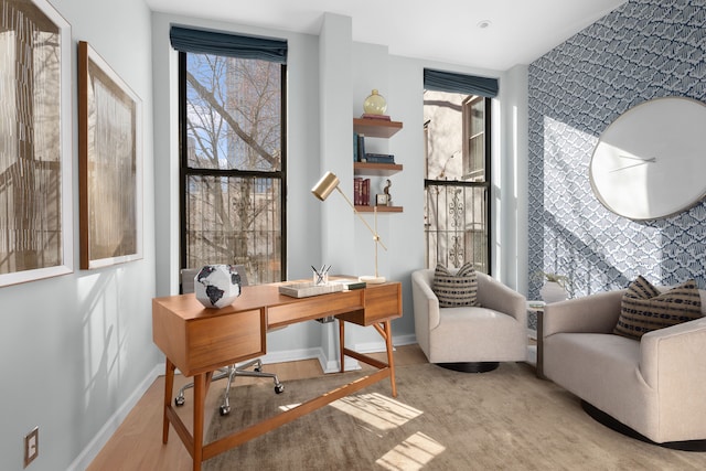 office area featuring an accent wall and baseboards