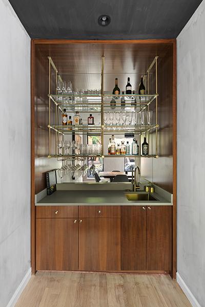 bar featuring wet bar, baseboards, light wood-type flooring, and a sink