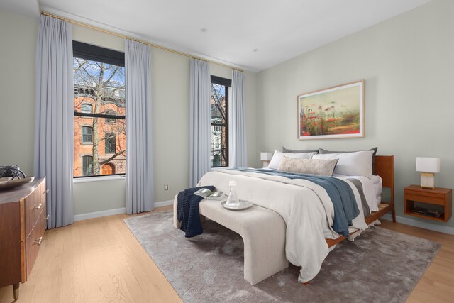 bedroom featuring baseboards and light wood finished floors