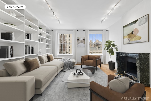 living room with track lighting and a high end fireplace