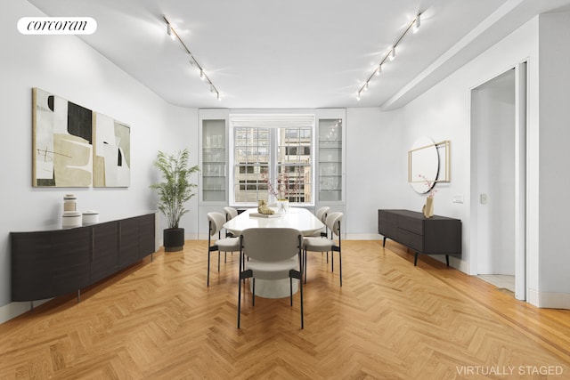 dining room with rail lighting and baseboards