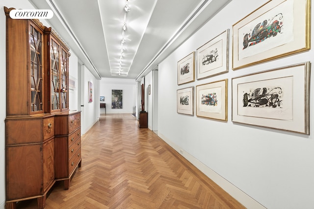 corridor featuring baseboards and track lighting