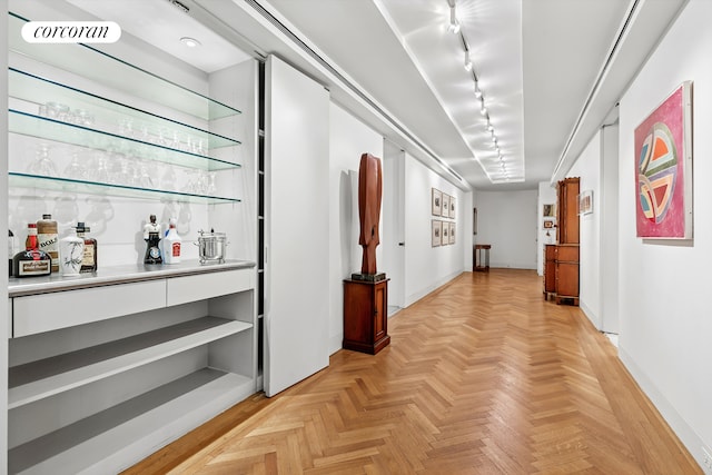 corridor with baseboards and rail lighting