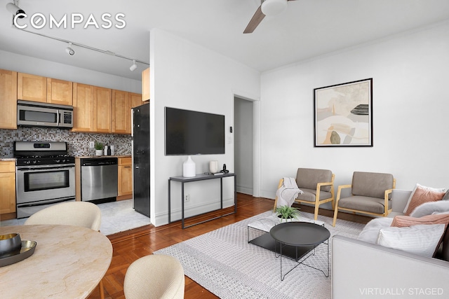 living room featuring baseboards and ceiling fan