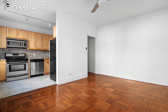 kitchen with a ceiling fan, backsplash, appliances with stainless steel finishes, light countertops, and baseboards