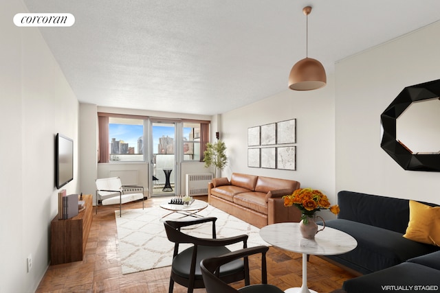 living room featuring visible vents, radiator, and a textured ceiling