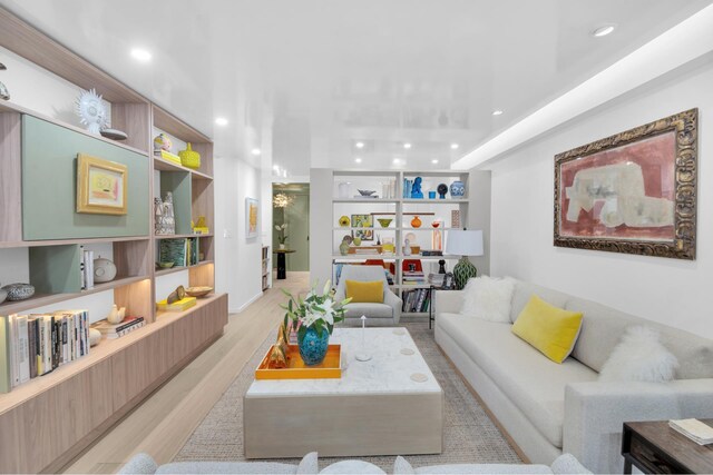 living room featuring recessed lighting, built in features, and light wood finished floors