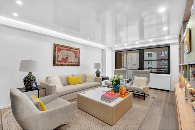 living area featuring recessed lighting, baseboards, and wood-type flooring