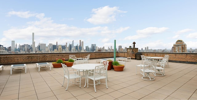 view of patio / terrace featuring outdoor dining area and a city view