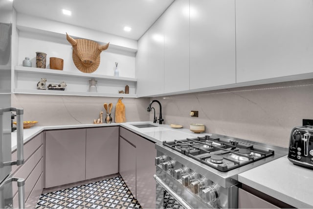 111 E 85th St Unit 10A, New York City, NY 10028 - kitchen with stainless steel gas stove, open shelves, a sink, and light countertops