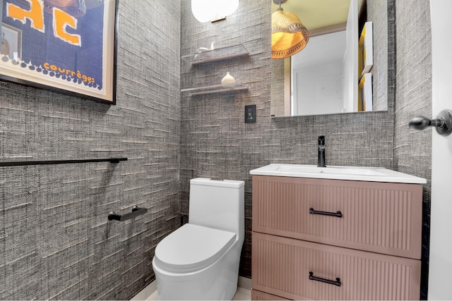 half bathroom featuring vanity, toilet, and tile walls