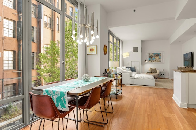 dining room featuring a notable chandelier, visible vents, light wood-type flooring, and baseboards