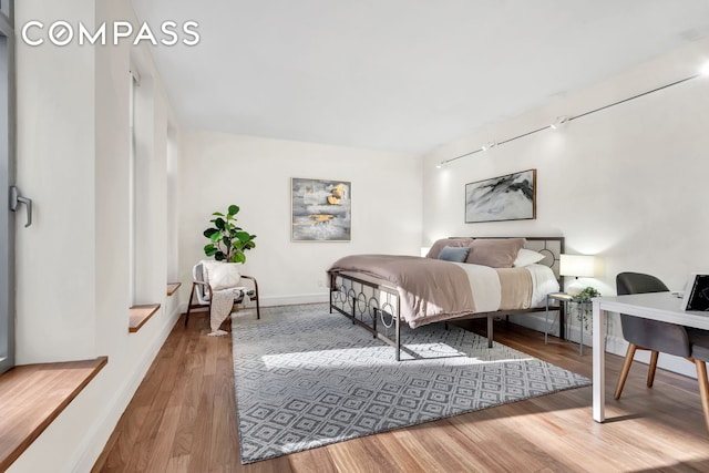 bedroom featuring baseboards and wood finished floors