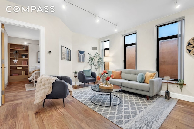 living room with visible vents, baseboards, and wood finished floors