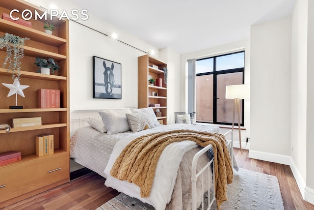 bedroom featuring wood finished floors and baseboards