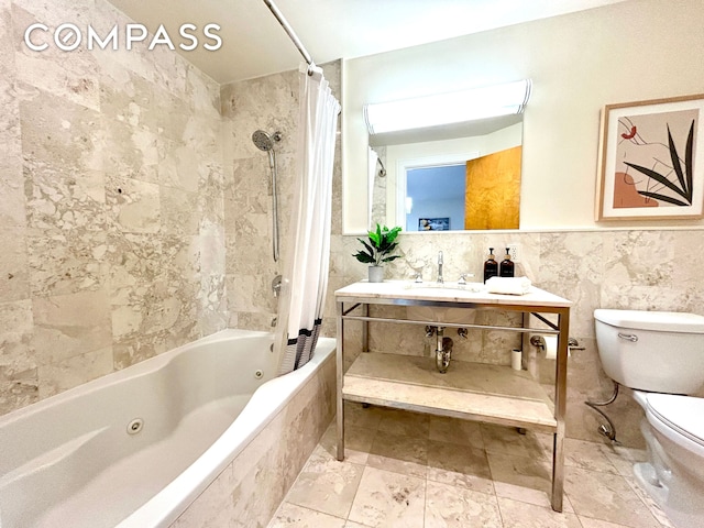 bathroom featuring vanity, a wainscoted wall, a combined bath / shower with jetted tub, tile walls, and toilet