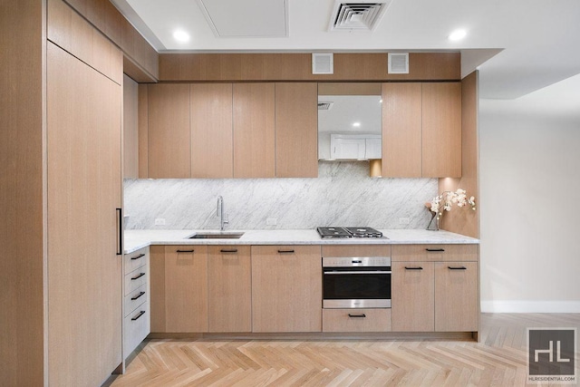 kitchen with a sink, light brown cabinets, visible vents, and stainless steel appliances