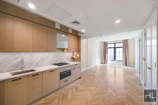 kitchen featuring visible vents, backsplash, open floor plan, appliances with stainless steel finishes, and a sink