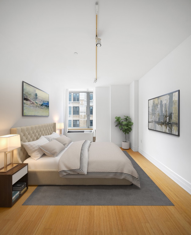 bedroom with baseboards and wood finished floors