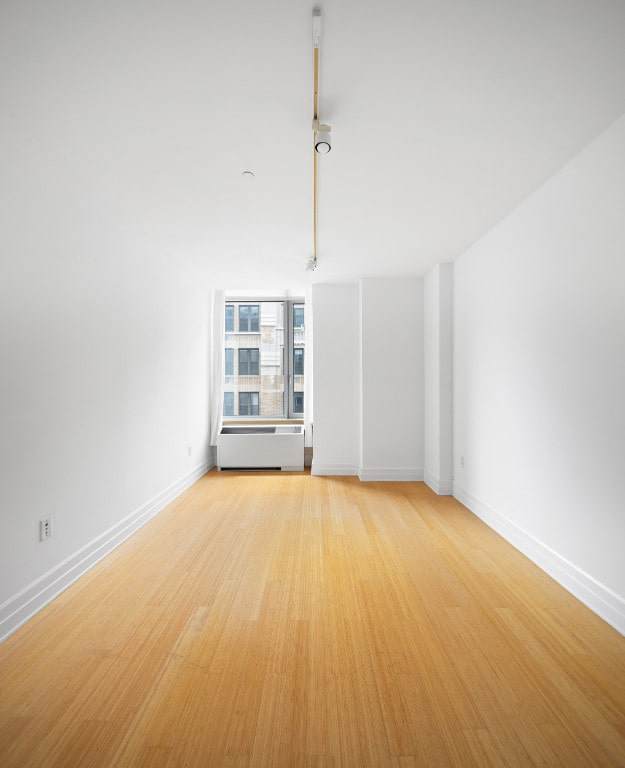 unfurnished room featuring baseboards and light wood-style flooring