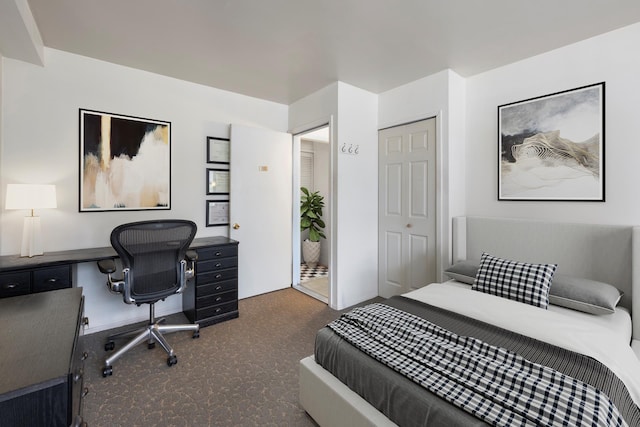 bedroom with carpet flooring, a desk, a closet, and baseboards
