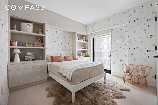 bedroom with light wood finished floors, wallpapered walls, and access to outside