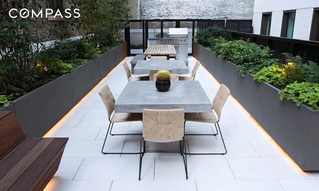 balcony with outdoor dining area, an outdoor kitchen, and a patio area