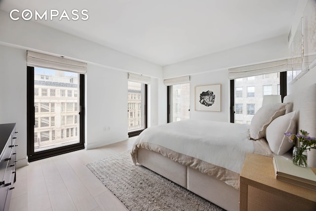 bedroom featuring multiple windows and wood finished floors