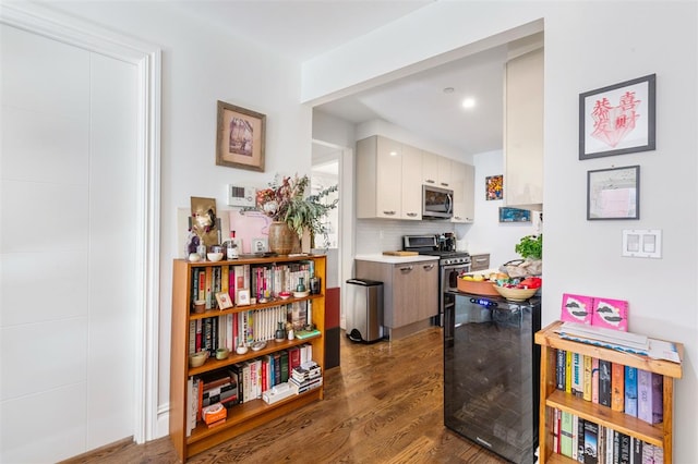 interior space featuring dark wood finished floors, light countertops, appliances with stainless steel finishes, white cabinetry, and backsplash