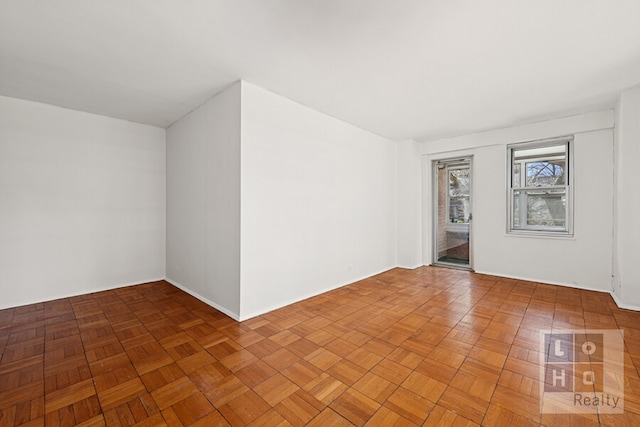 unfurnished room with baseboards