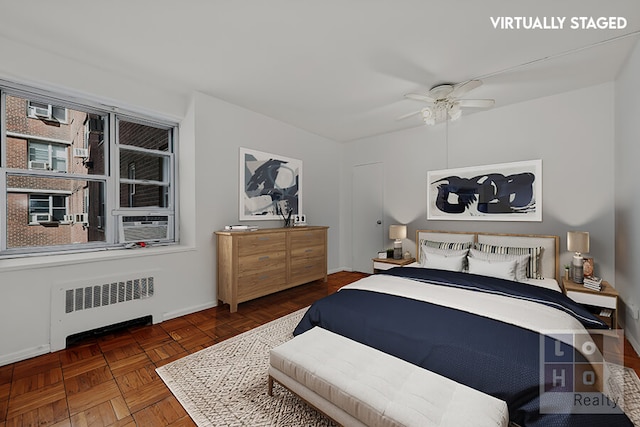 bedroom featuring baseboards, radiator heating unit, and a ceiling fan