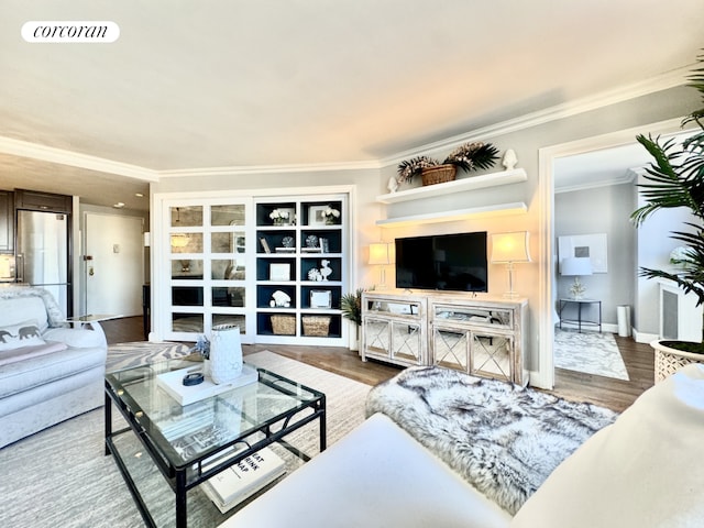 living room with crown molding, wood finished floors, visible vents, and baseboards