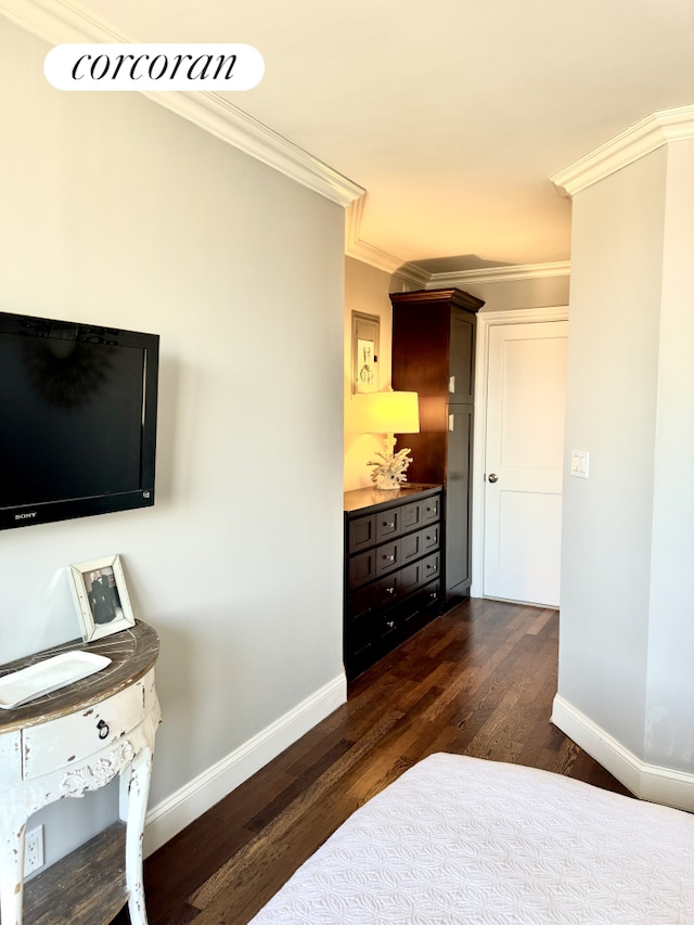 bedroom featuring dark wood finished floors, crown molding, and baseboards